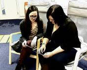 Two ladies sitting down talking.
